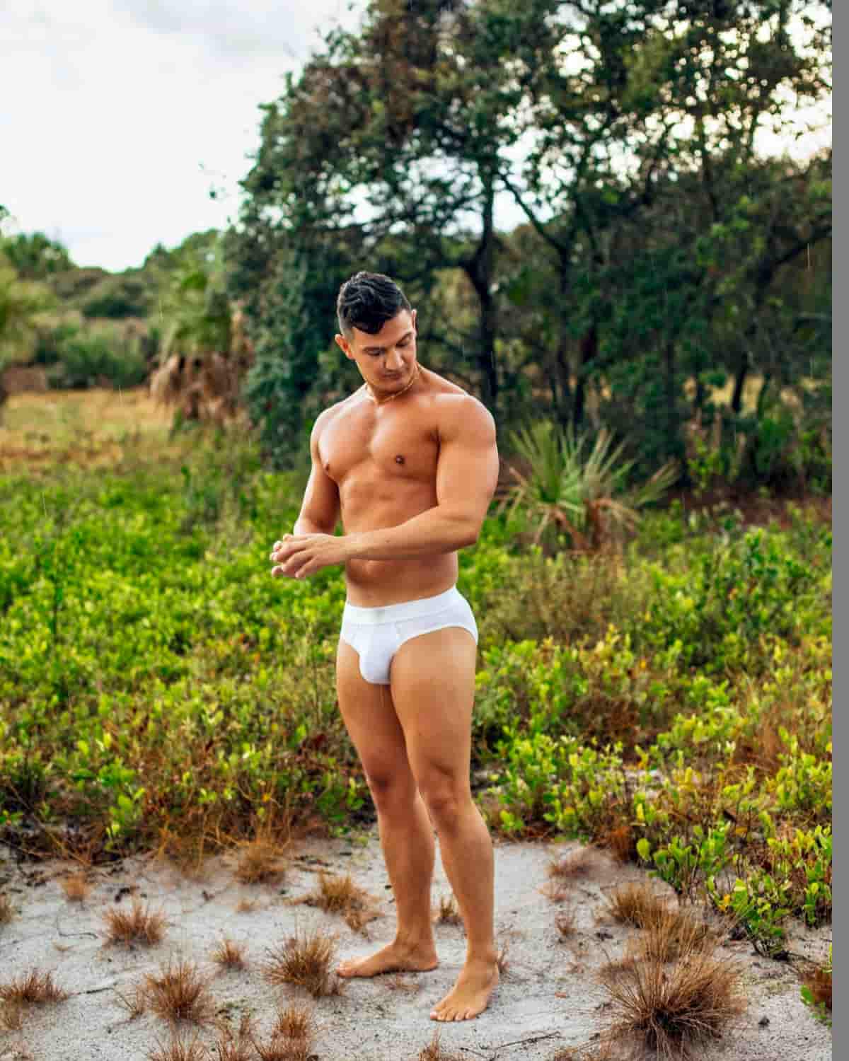 Man wearing a white thong in a natural outdoor setting