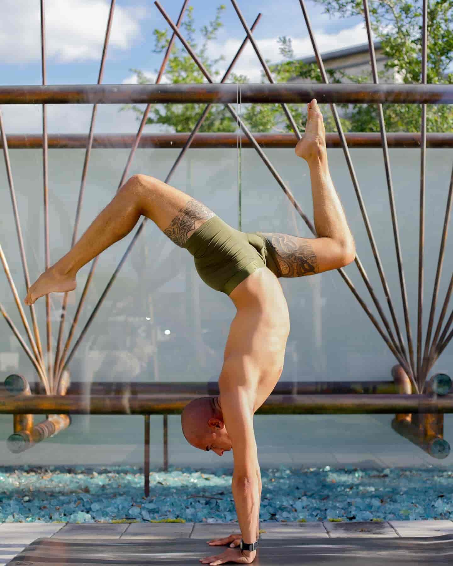 Man wearing AL{PHX Boxer Briefs in Moss Green doing a handstand