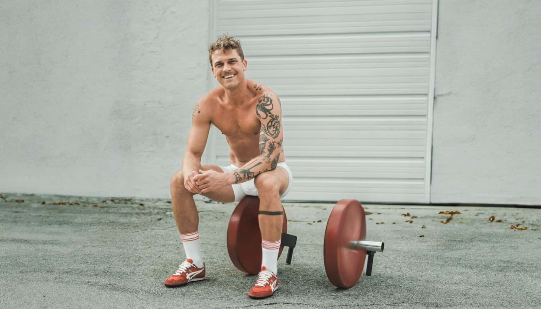 Man sitting on a barbell in front of a gray wall wearing Frost White Modern Fit Boxer Briefs