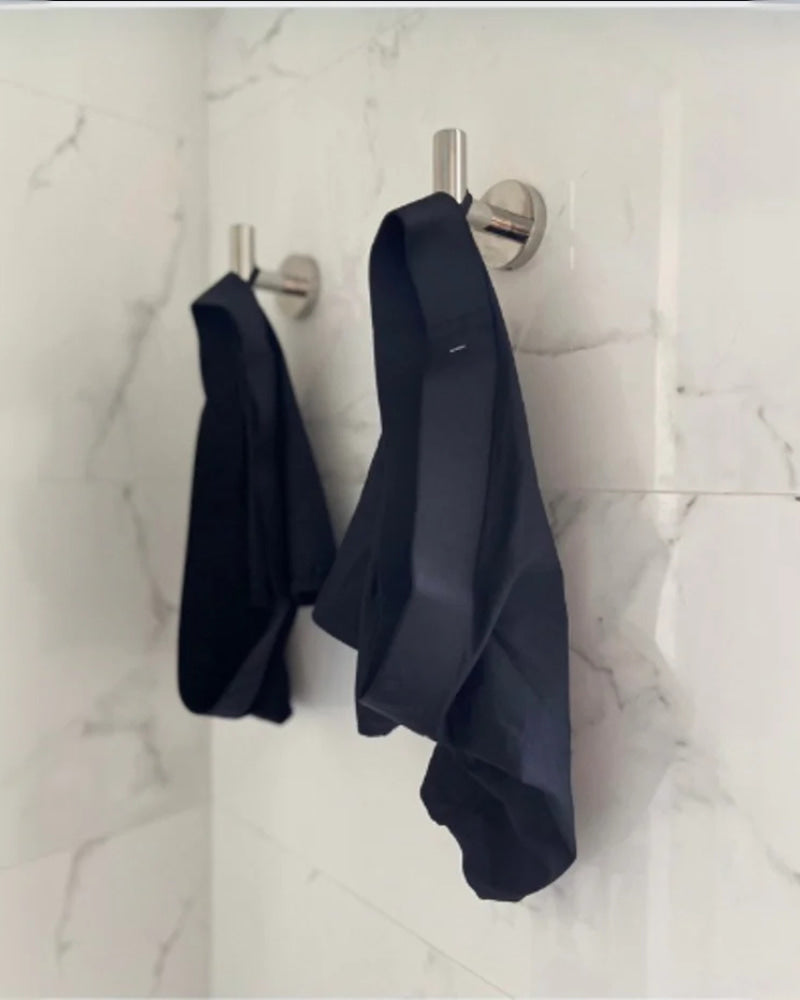 Two pairs of ALPHX underwear hanging neatly from wall hooks using the built-in locker loops—designed for post-shower convenience and daily organization.