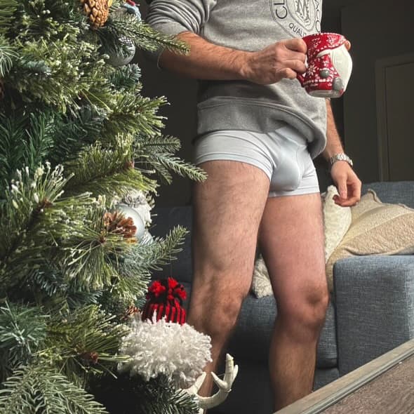 Man wearing ALPHX Modern Fit Trunk with Contoured Pouch in Glacier Blue with coffee
